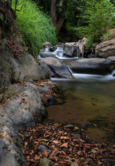 Naklejka na ściany i meble Water stream on the river with small waterfalls