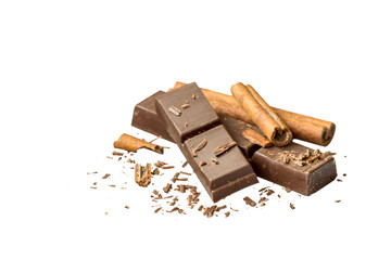   Pieces of dark bitter chocolate and cinnamon sticks on a white background. 