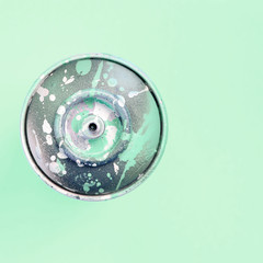 Single used spray can for graffiti drawing lies on a pastel colored backgroung. Street art painting...