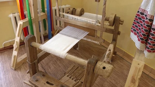 Weaving machine with a piece of linen cloth handmade. Wooden loom. Linen cloth is woven on a wooden machine.