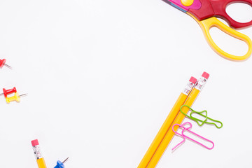 Two paper clips talking while lying on a white floor and on a pencil. Miniature school life and back to school concept with copy space white background. 