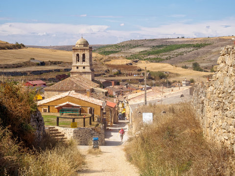 Belltower of the 16th century parish church of the Conception tucked down in a small valley of the Meseta - Hontanas, Castile and Leon, Spain
