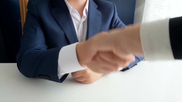 Closeup 4k footage of corrupted official shaking hands with businesswoman and receiving bribe