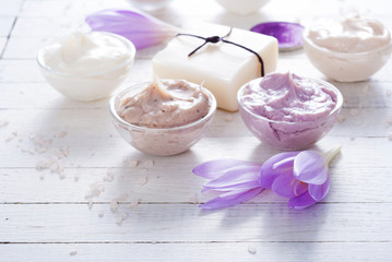 cosmetic cream variations, soap and autumn crocus herbal flower on white wooden table