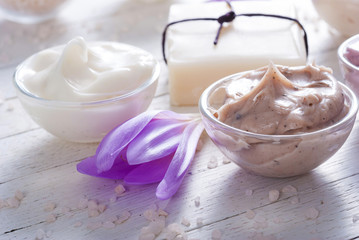 cosmetic cream variations, soap and autumn crocus herbal flower on white wooden table