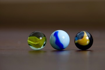 glass Marbles on dark wooden floor