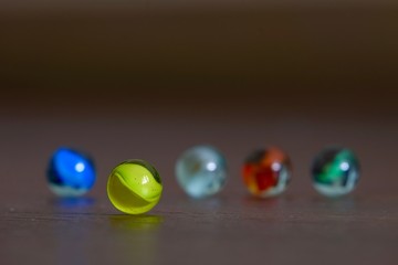 glass Marbles on dark wooden floor