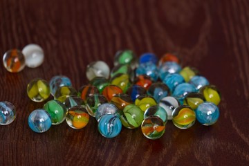 glass Marbles on dark wooden floor