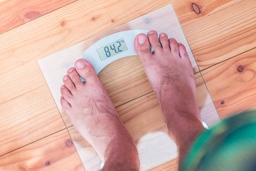 Male bare feet on weight scale