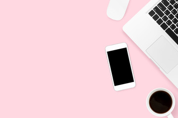 Pink pastel office desk table with smartphone, laptop and supplies. Top view with copy space, flat lay.