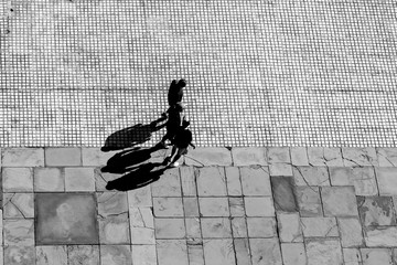 Looking down on three people walking in early morning, with their shadows behind them