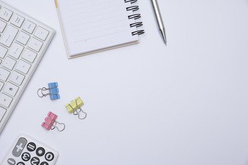 Top view of office supplies and notebook on white background and copy space for insert text.