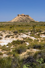 Fototapeta na wymiar Spain, Bardenas Reales: Panorama view of famous Spanish natural semi desert sierra natural preserve park with Pisquerra rocky mountain chain, wide plains and blue sky - concept travel nature badlands