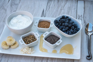 Fototapeta na wymiar Healthy Breakfast Choice Ingredients-Greek Yogurt with fruit, flax seeds, sunflower seeds, chia seeds and honey