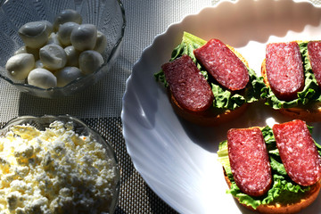 Rustic bread with herbs and salami sausage. Garlic buns. Sandwiches.Cottage cheese, traditional Italian mozzarella cheese for making Italian pizza.