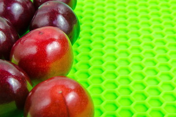Red ripe cherry on a light green base close-up.