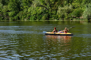 People floating on kayaks on the river.