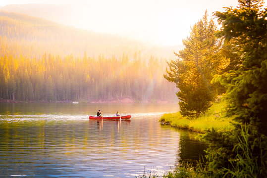 couple in a canoe on a mountain lake during autumn.
