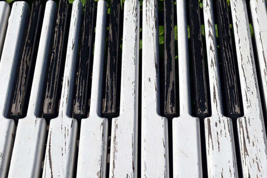 Black-and-white wooden piano keys. Bench in the form of piano.