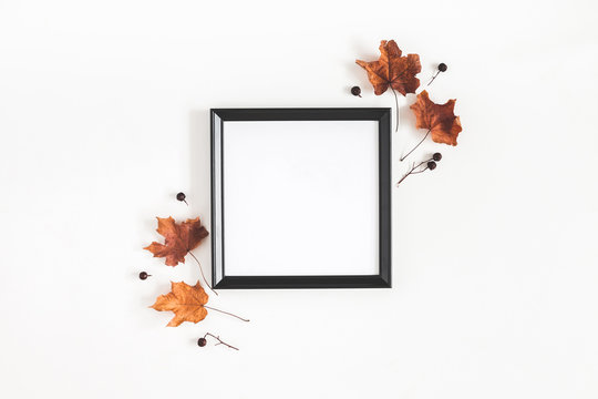 Autumn composition. Photo frame, dried leaves on white background. Autumn, fall, halloween concept. Flat lay, top view, copy space, square