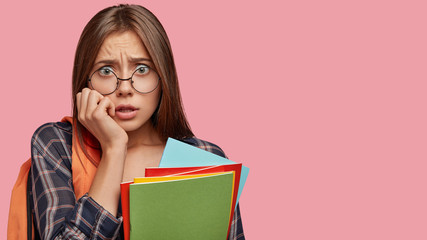 Nervous stressful student worries before presenting diploma paper in auditorium, keeps hand on...