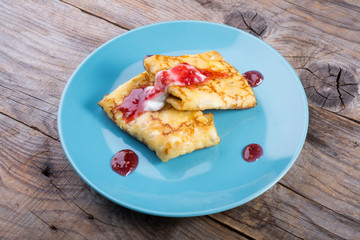 Pancakes served with cream and red jam