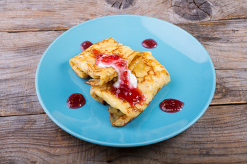 Pancakes served with cream and red jam
