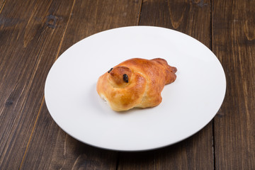 Sweet baked bun on a white plat