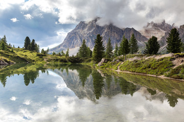 Lago di Limides — a tiny lake hidden in the heart of the Dolomites. The lake is surrounded by mountains which reflecting in it. South Tyrol, Alps, Italy. 