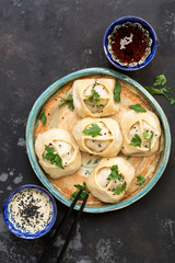 Asian steamed dumplings, black concrete background, soy sauce, sesame. Top view , flat lay . ASIAN FOOD.