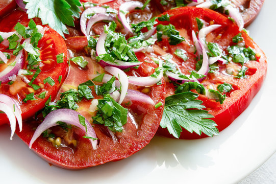 sliced tomatoes under fresh marinade of white vinegar, olive oil, garlic, parsley, and oinon
