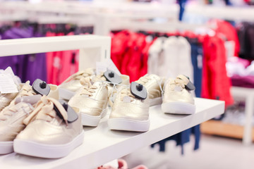 Children sneakers on the shelves in the store