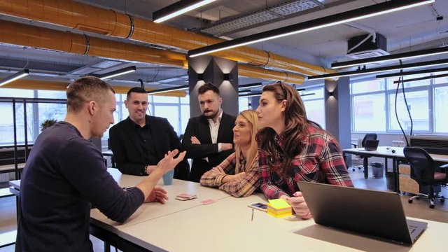 Man explaining magic trick to his colleagues in the office