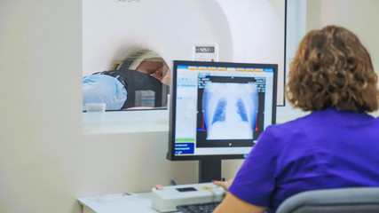 Elderly patient is scanned by MRI, CT scanner at modern hospital.