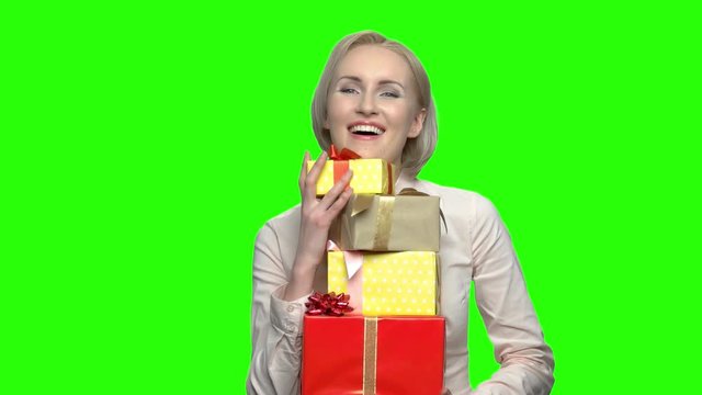 Mature woman recieved many gift boxes for her birthday. Green hromakey background for keying.