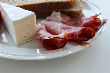 Brotzeitteller mit Schinken, Weichkäse, Toast und Tomaten