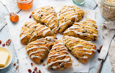 Scones with oats, cranberry and pecan nuts on wooden background. Top view.