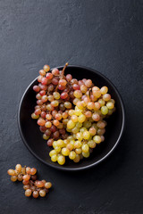 Fresh grape in bowl on a slate background. Top view.