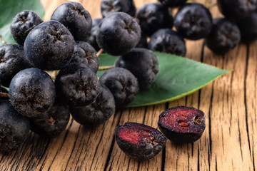 Berries of black mountain ash on a wooden background. Aronia melanocarpa. Therapeutic properties of black mountain ash. Super antioxidant.