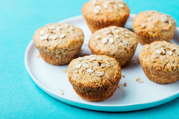 Healthy vegan oat muffins, apple and banana cakes with sour cream on a white plate. Blue background.