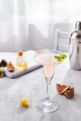 Bellini cocktail with peach and figs, honey on light background over windows, flat lay with copy space