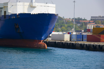 Shore crane loading containers in freight ship