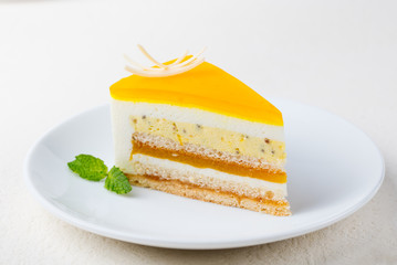 Passion fruit cake, mousse dessert on a white plate.