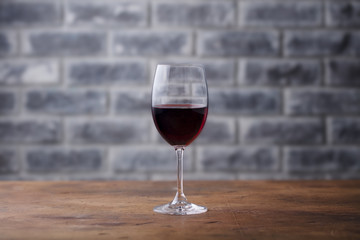 Glass of red wine on stone wall background. Copy space.