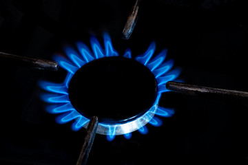 burner gas stove in the on state. Blue flame in a dark key