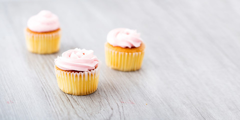 Tasty cupcake on wooden background. Birthday cupcakes on gray wooden background. Space for Text.