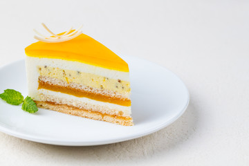 Passion fruit cake, mousse dessert on a white plate. Copy space.