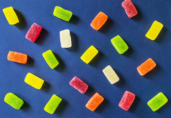 Colorful gummy candies pattern on a blue background