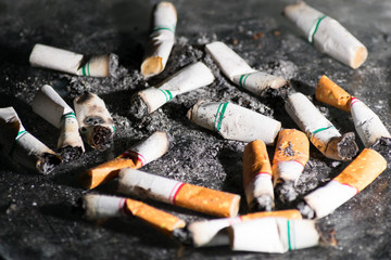 Close-up Cigarettes butts wastes dumped and scattered all over the floor. Smoking is bad for your health.