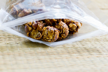 Chocolate covered popcorn in a clear plastic bag.